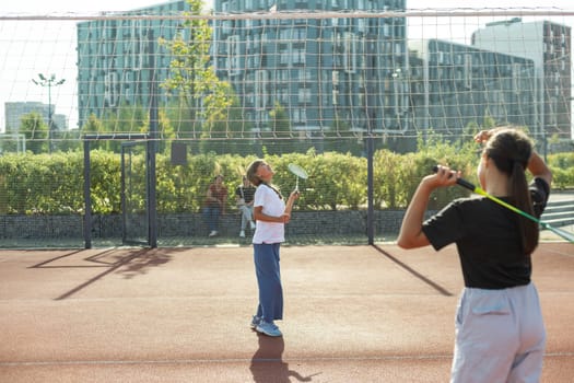Two girls with badminton rackets on the football field. High quality photo