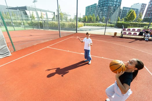 Children and sports. Teenage girl playing basketball on the playground. High quality photo