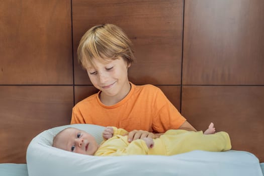 A young boy lovingly holds his newborn brother in a cozy sleep cocoon, sharing a tender sibling moment. A heartwarming scene of family bonding, protection, and the start of a lifelong brotherly connection.