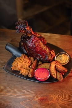 Juicy baked pork knuckle served beautifully on a plate with a shovel. A delicious photo for a menu, culinary website, or an advertisement for catering establishments