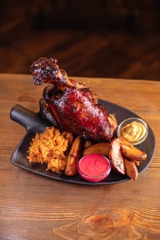 Juicy baked pork knuckle served beautifully on a plate with a shovel. A delicious photo for a menu, culinary website, or an advertisement for catering establishments