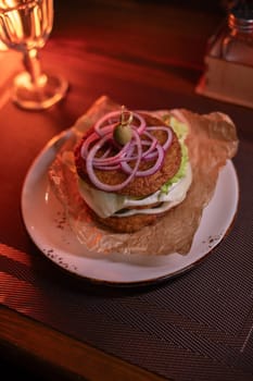 Juicy burger made from draniki and meat patties, lettuce, onion on top and olive. A delicious photo for a menu, culinary website, or an advertisement for catering establishments.