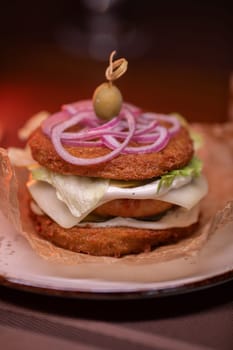 Juicy burger made from draniki and meat patties, lettuce, onion on top and olive. A delicious photo for a menu, culinary website, or an advertisement for catering establishments.