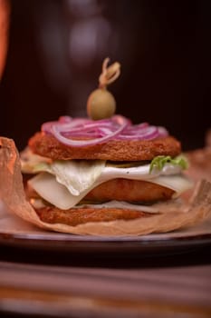 Juicy burger made from draniki and meat patties, lettuce, onion on top and olive. A delicious photo for a menu, culinary website, or an advertisement for catering establishments.