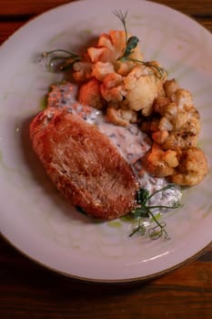 Baked turkey and cauliflower are a delicious dish on the menu at the restaurant. A beautiful and delicious photo for a menu, culinary website, or an advertisement for catering establishments.