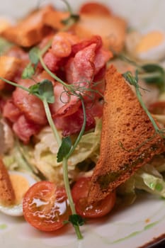 Caesar salad with bacon is mouthwatering and delicious. A beautiful perfect photo for a cafe or restaurant menu, advertisement, culinary website. Suitable for design.