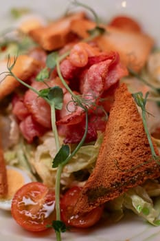 Caesar salad with bacon is mouthwatering and delicious. A beautiful perfect photo for a cafe or restaurant menu, advertisement, culinary website. Suitable for design.