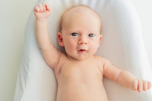 Adorable baby lying safely in a cozy infant cocoon. Comfortable and protective design for newborn care. Parenting, safety, and baby comfort concept.