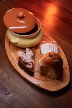 Restaurant dish borscht, delicious bread with bacon, sour cream, bun. A delicious photo for a menu, culinary website, or an advertisement for catering establishments