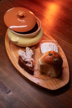Restaurant dish borscht, delicious bread with bacon, sour cream, bun. A delicious photo for a menu, culinary website, or an advertisement for catering establishments