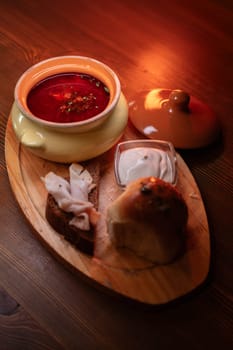 Restaurant dish borscht, delicious bread with bacon, sour cream, bun. A delicious photo for a menu, culinary website, or an advertisement for catering establishments