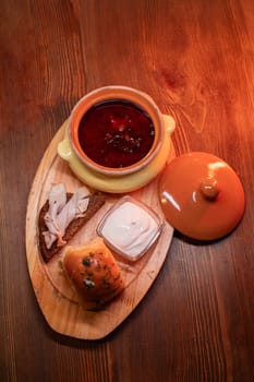 Restaurant dish borscht, delicious bread with bacon, sour cream, bun. A delicious photo for a menu, culinary website, or an advertisement for catering establishments