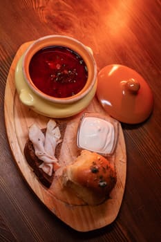 Restaurant dish borscht, delicious bread with bacon, sour cream, bun. A delicious photo for a menu, culinary website, or an advertisement for catering establishments