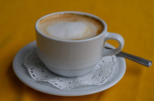 Sipping a delightful cup of coffee while enjoying a moment of peace on a bright and cheerful day.