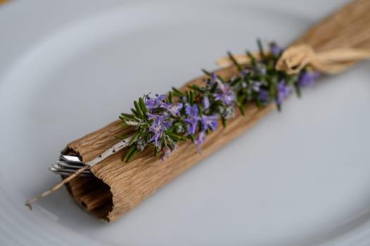 Fresh rosemary wrapped in natural materials adds a touch of nature to a summer dining experience.