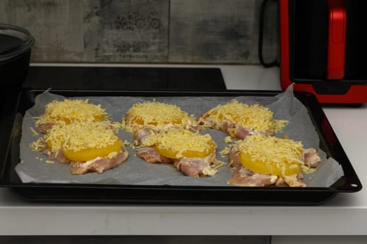 Tender chicken pieces, pineapple slices, and melted cheese garnished, ready to be baked into a savory dish.