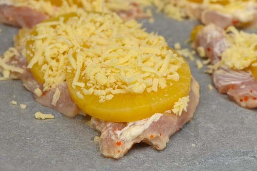 Tender chicken fillets are layered with sweet pineapple rings and shredded cheese, ready for the oven’s warmth.