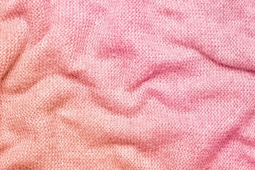 A soft and textured gradient pink knitted fabric with gentle waves and folds, creating a cozy and warm appearance. Ideal for textile backgrounds, fashion, or home decor themes.