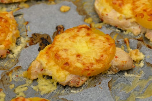 Juicy baked chicken pieces adorned with bubbling cheese and sweet pineapple, promising a flavorful culinary delight