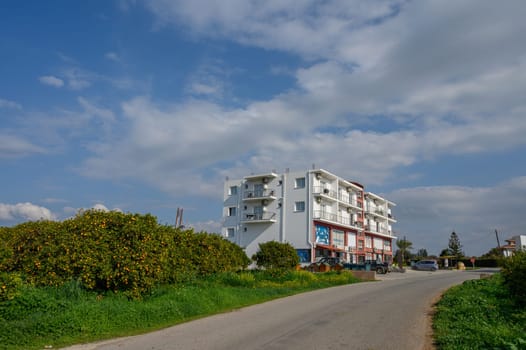 A bright and inviting setting where a contemporary building stands alongside a winding road, surrounded by nature.
