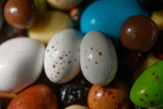 Brightly colored decorative eggs rest among candies, embodying the spirit of spring celebrations.