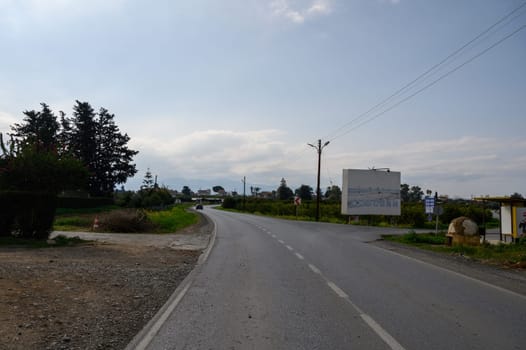 A peaceful stretch of road surrounded by greenery invites travelers to explore the tranquil countryside.