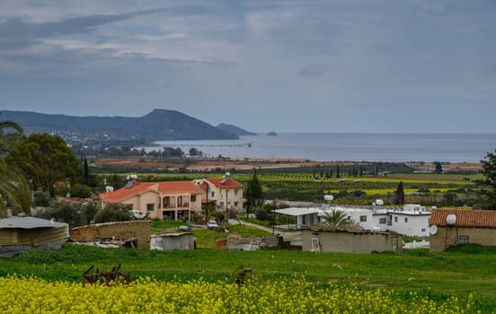 Lush fields stretch towards the horizon, blending vibrant greens with the calm blue of the distant sea at twilight.
