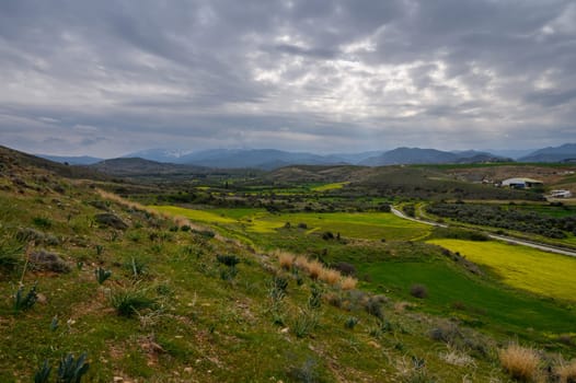 Rolling green hills under a cloudy sky invite tranquility and a connection with nature.