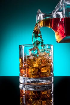 Pouring a glass of liqour from a glass bottle.