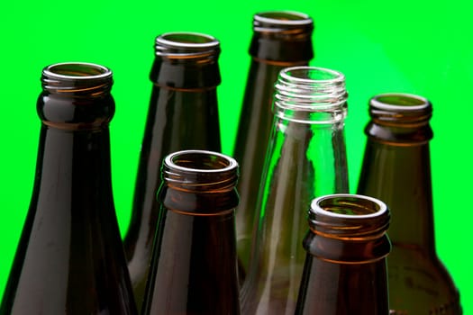 A close up of several brown glass bottles and one clear glass bottle.