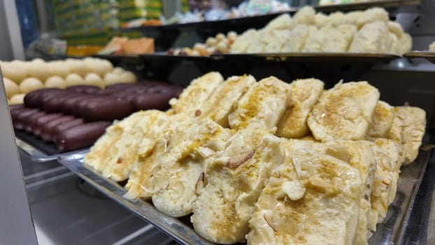 Colorful confectioneries are beautifully arranged in a busy dessert shop.