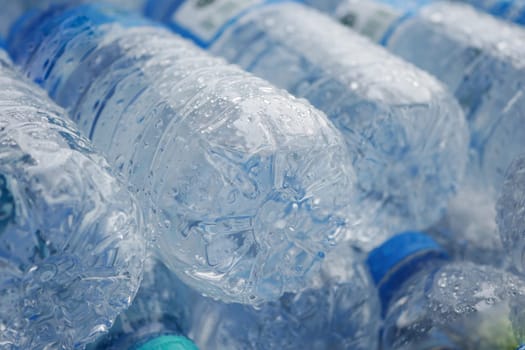 Multiple clear water bottles are tightly packed, showing condensation.