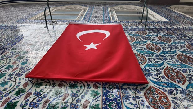 A vibrant Turkish flag hangs prominently against decorated tiles.