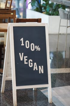 A sign displays 100 percent vegan options in a cozy dining area.