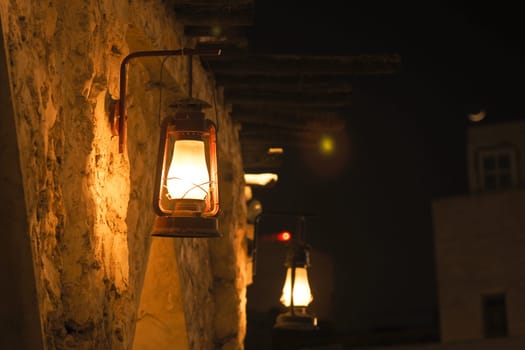 Warm light from lanterns enhances a tranquil night atmosphere outdoors.