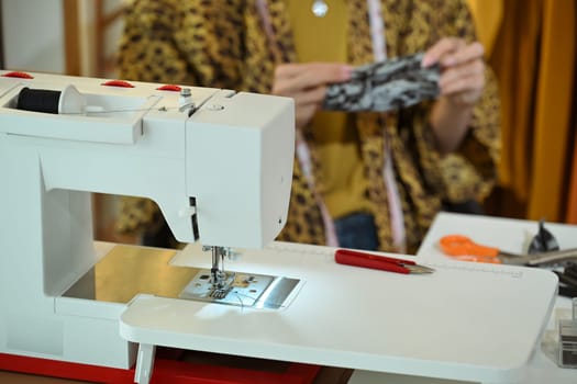 Close up of a modern sewing machine in a designer workspace.
