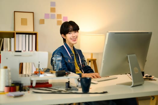 Portrait of confident young fashion designer working in a creative studio.
