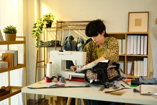 Fashion designer sewing custom garment in a creative studio.