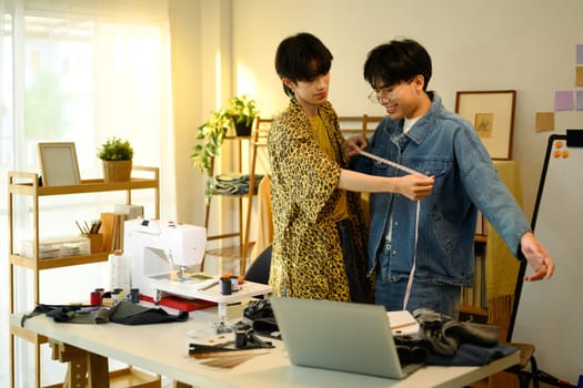 Two young designers brainstorming ideas while working on denim collection.