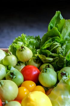 Vegetables in a basket on a dark background. Healthy food.
