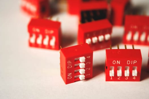 This image showcases a cluster of vibrant red DIP switches featuring white toggle switches, emphasizing their intricate design and electronic functionality in circuits.