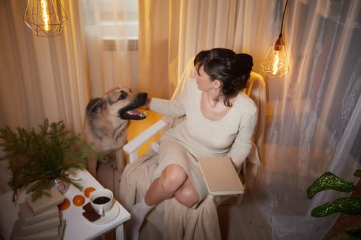 In a comforting apartment, a middle-aged woman relaxes with her dog, surrounded by warm lighting and cozy decor during the evening.
