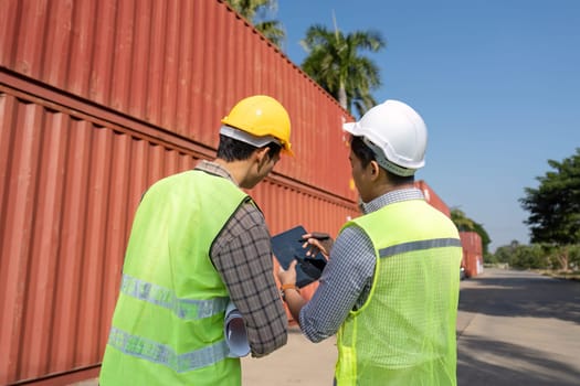 Engineers engage in discussion about logistics operations, reviewing plans in a shipping yard setting.