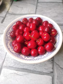 ripe juicy red cherry on a plate covered with droplets of moisture