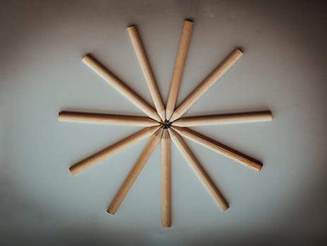 Top view of Brown crayons arranged in a circle on silver background. Wooden colored pencils come together and circle, An artistic display of colored pencils, Stationery for drawing, Minimalism art supplies dark concept, Empty space for text, design and wallpaper, Selective focus.