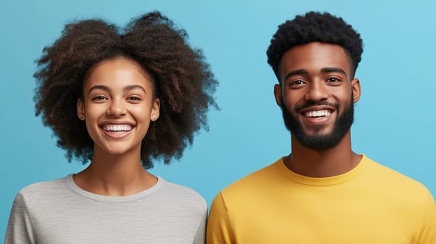 Portrait of modern happy laughing young African teenage couple, black woman and man joyful smiles together on blue studio background