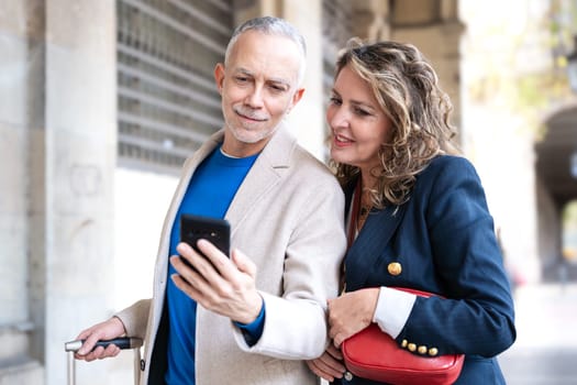 Traveler adult couple using smartphone or mobile phone to search information about hotels, shopping malls and transportation guides on the app. lifestyle and travel concept.