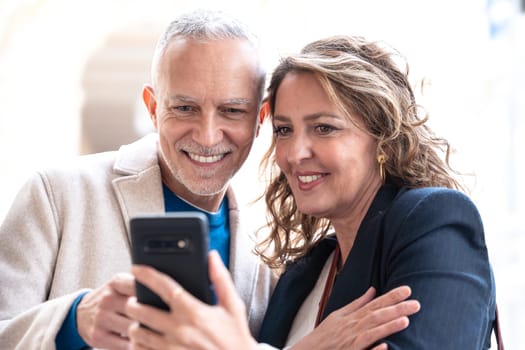 Traveler adult couple using smartphone or mobile phone to search information about hotels, shopping malls and transportation guides on the app. lifestyle and travel concept.