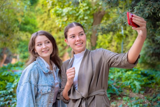 Two young caucasian women taking a selfie with smartphone.