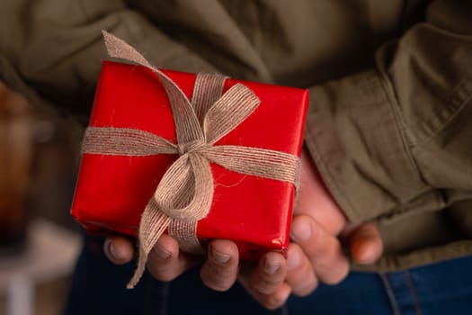 portrait young man hides small box to give to his partner.Valentine's Day.